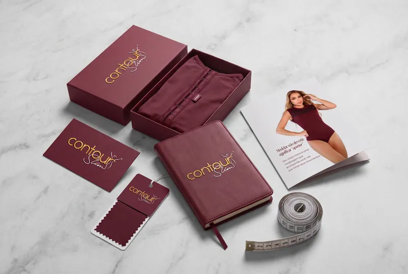 Papelaria e catálogo Contour Slim sobre mármore