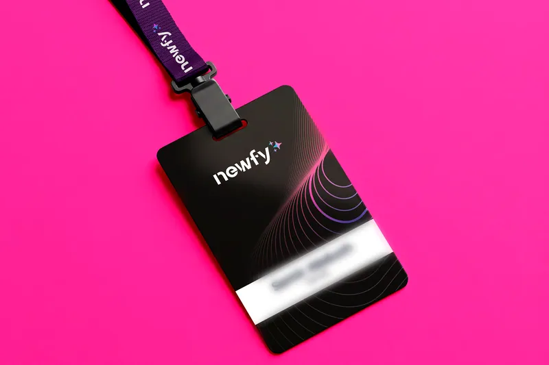 Crachá preto com o logotipo Newfy sobre fundo rosa