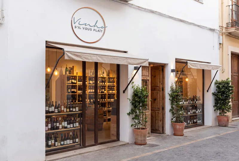 Fachada branca de loja de vinhos com o logotipo S'il Vous Plaît